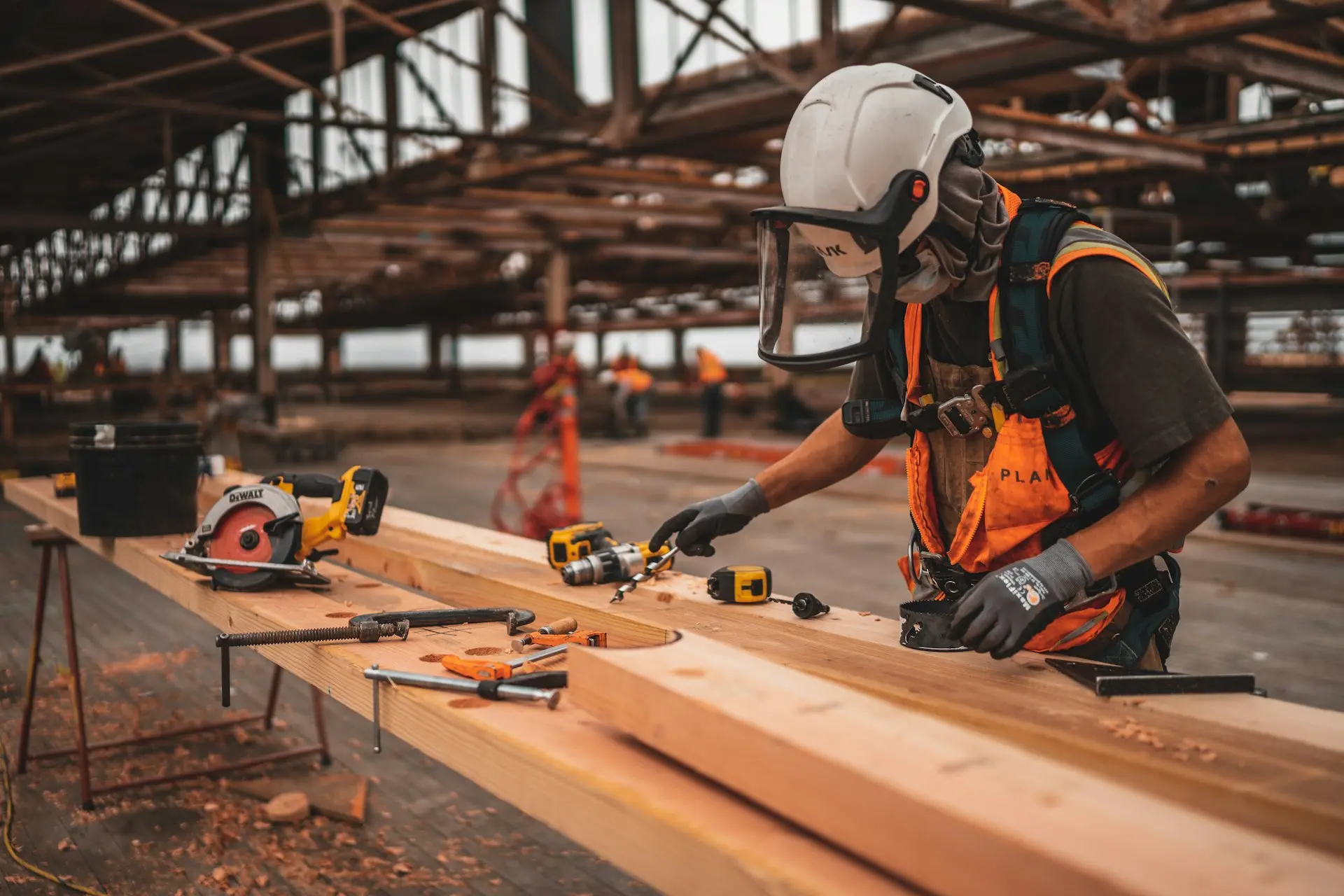 Ouvrier du bâtiment utilisant des outils sur chantier avec équipements de protection