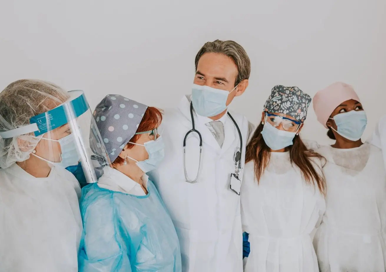 Personnel médical en blouse et masque dans un environnement hospitalier