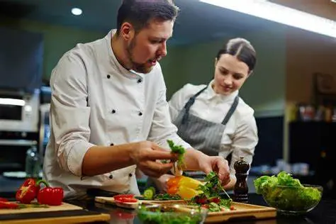 Chefs cuisiniers préparant des plats en cuisine professionnelle